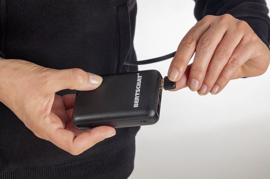 Zwarte powerbank van "BERTSCHAT" die wordt aangesloten op een snoer van een hoodie.