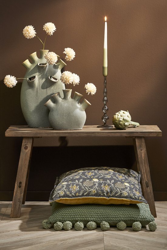 Houten bankje met kussens onderop en decoratieve vazen met bloemen.
