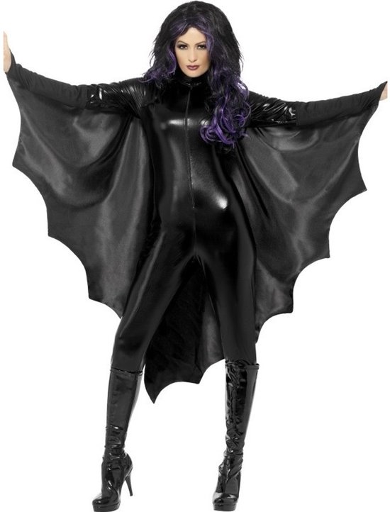Femme portant un costume de vampire noir brillant avec des ailes de chauve-souris, des reflets violets et des bottes hautes.