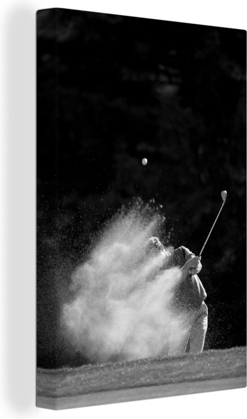 Canvas Schilderij Een mannelijke golfer slaat de golfbal uit de bunker op het green - zwart wit - 60x90 cm - Wanddecoratie