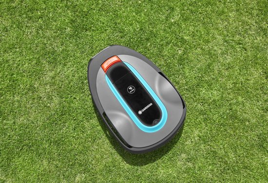 Grijze robotmaaier met blauwe en oranje accenten op een groen gazon.