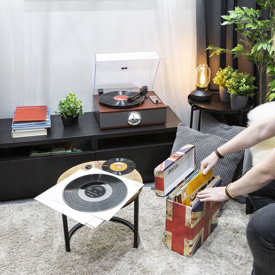 Retro platenspeler in een woonkamer op een kast, met vinylplaten in een opbergdoos met Britse vlagprint.