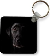 Sleutelhanger - Een zwarte Labrador Retriever op een zwarte achtergrond - Plastic - Rond - Uitdeelcadeautjes
