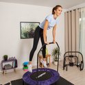 Vrouw met paarse fitness trampoline met handgreep.