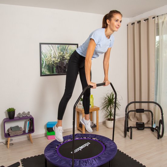 Vrouw met paarse fitness trampoline met handgreep.
