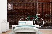 Behang - Fotobehang Groene fiets bij het hek - Breedte 330 cm x hoogte 220 cm