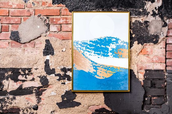 Cadre photo doré avec peinture de paysage abstrait accroché à un mur de briques.