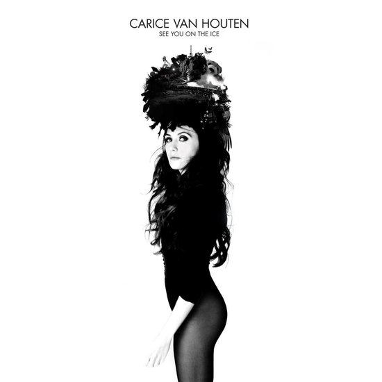 Carice van Houten pose in een zwarte body en panty's met een grote, donkere hoofdversiering.