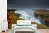 Behang - Fotobehang Waterdamp van de Gullfoss waterval in IJsland - Breedte 600 cm x hoogte 400 cm