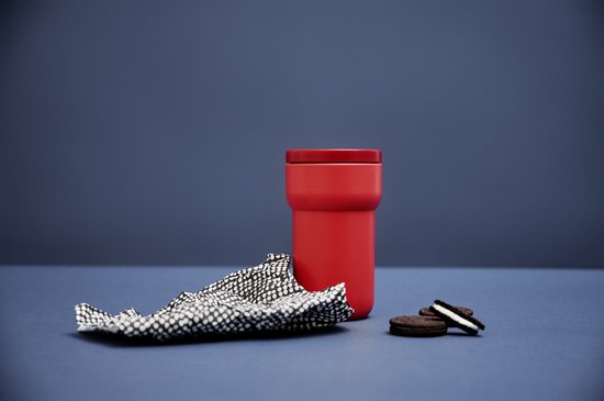 Tasse rouge vif avec couvercle rouge, à côté de biscuits.