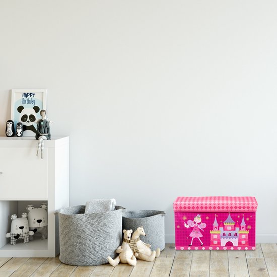 Witte muur met roze speelgoedkist met prinsessenkasteel en prinses op houten vloer.