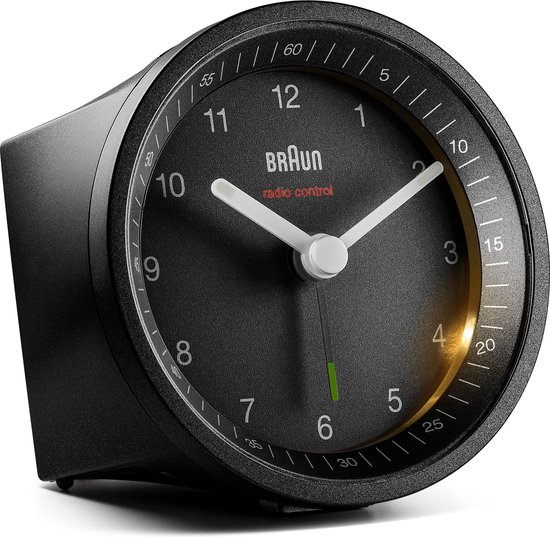 Zwarte Braun wekker met analoge wijzerplaat en witte wijzers, van voren gezien met licht aan de zijkant.