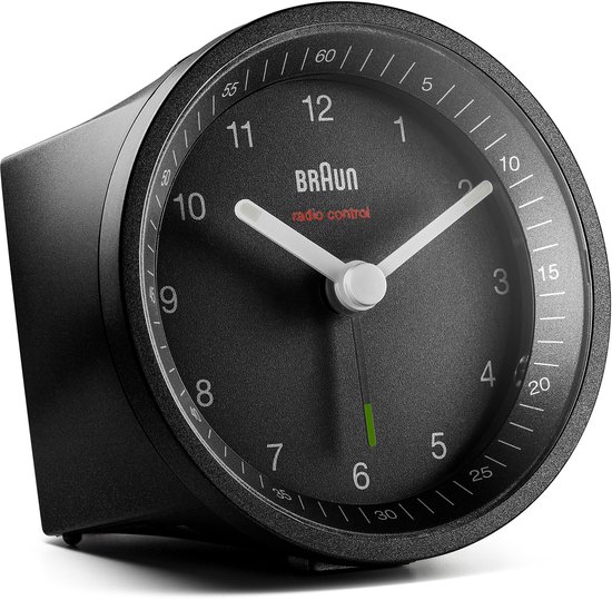 Zwarte Braun wekker met analoge wijzerplaat, witte wijzers en groene secondewijzer, van opzij gezien.