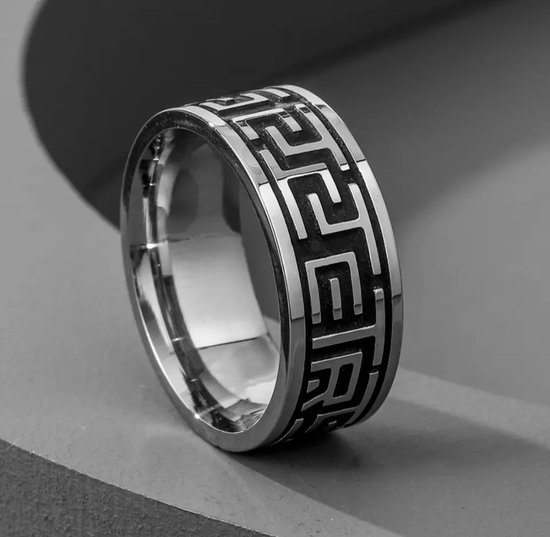 Zilverkleurige ring met een geometrisch patroon aan de buitenzijde.