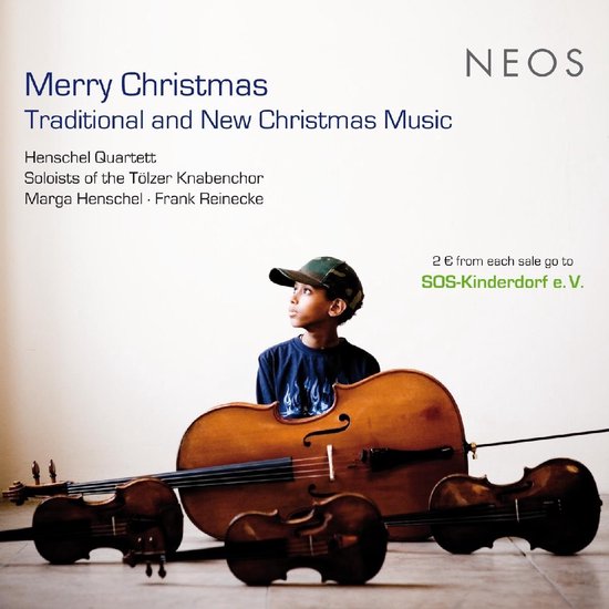 Jongen met kerstmuts kijkt omhoog, naast een cello en twee violen
