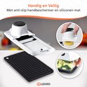 Witte mandoline snijder met gele courgetteplakjes. Zwarte siliconen mat en handbeschermer liggen ernaast.