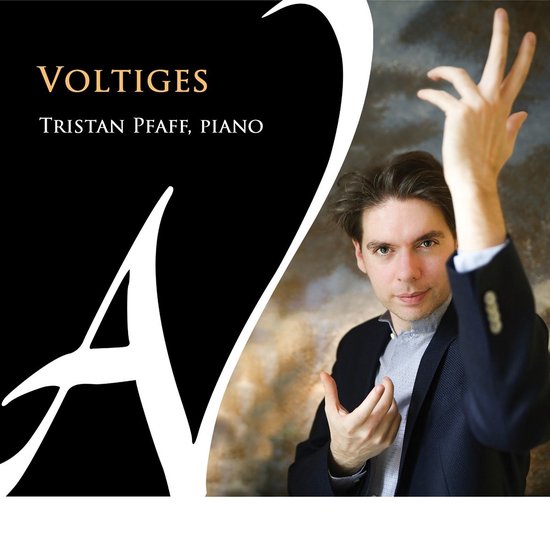 TRISTAN PFAFF, PIANO. Man in donkerblauw jasje en lichtblauw gestreept shirt met opgestoken hand.