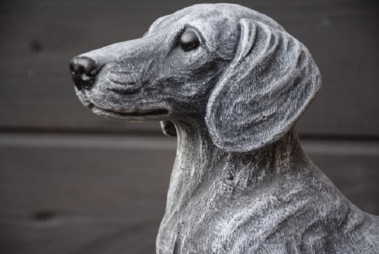 Gros plan d'une statue de teckel grise.