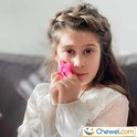 Meisje met gevlochten haar houdt een roze ster met maantje voor haar wang.