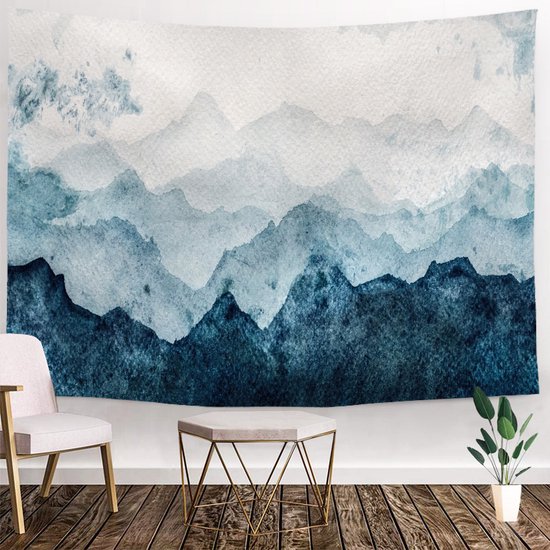 Tenture murale avec paysage de montagne aquarelle dans des tons de bleu et blanc, au-dessus d'une chaise et d'une table d'appoint.