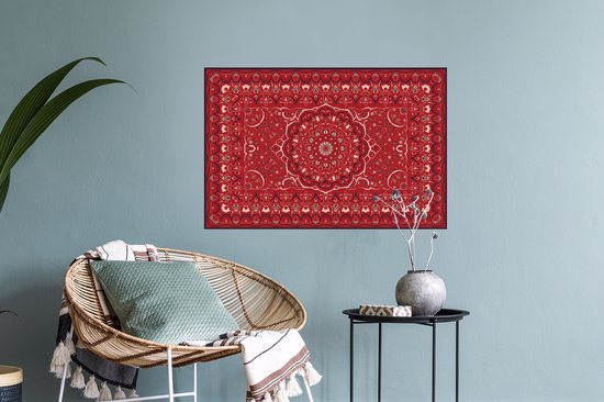 Une affiche de tapis persan rouge avec un design de mandala, accrochée au-dessus d'un fauteuil.