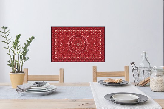 Une affiche de tapis persan rouge avec un design de mandala, accrochée au-dessus d'une table à manger.