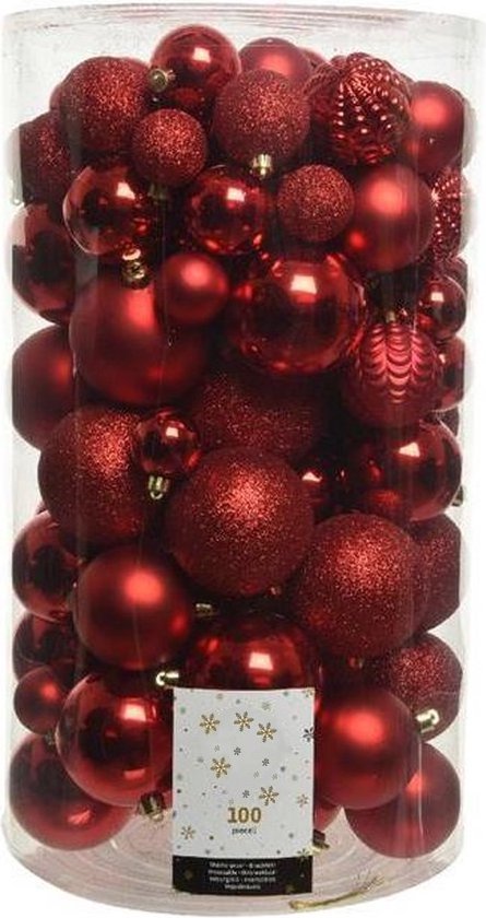 Een doorzichtige koker gevuld met 100 rode kerstballen in diverse maten en afwerkingen. Een deel is glanzend, de ander mat of met glitter.