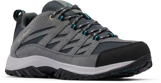 Schuin vooraanzicht van grijze wandelschoen met Columbia logo, blauwe veters en mesh details.