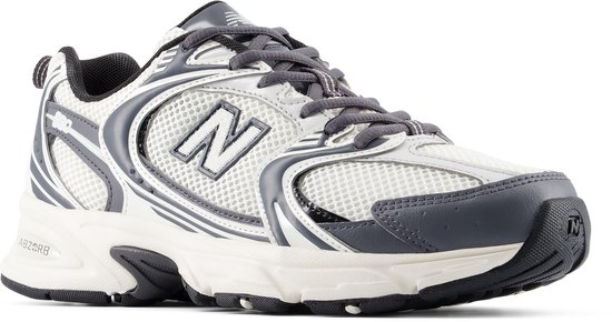 Zijprofiel van een witte en grijze New Balance sneaker met mesh-details en 'N' logo.