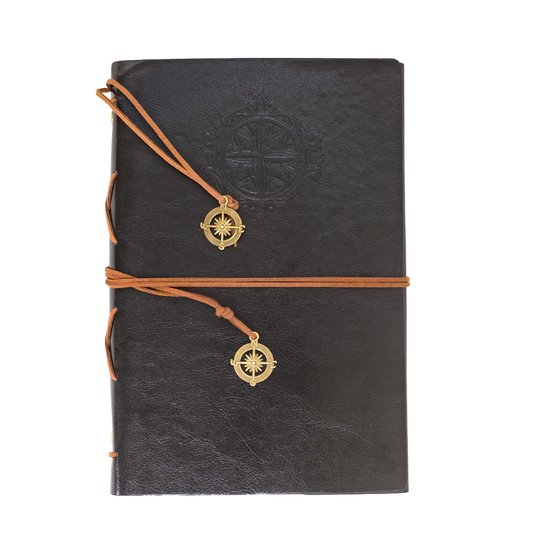 Carnet noir avec ornement de boussole, lanière en cuir marron et breloques boussole dorées.