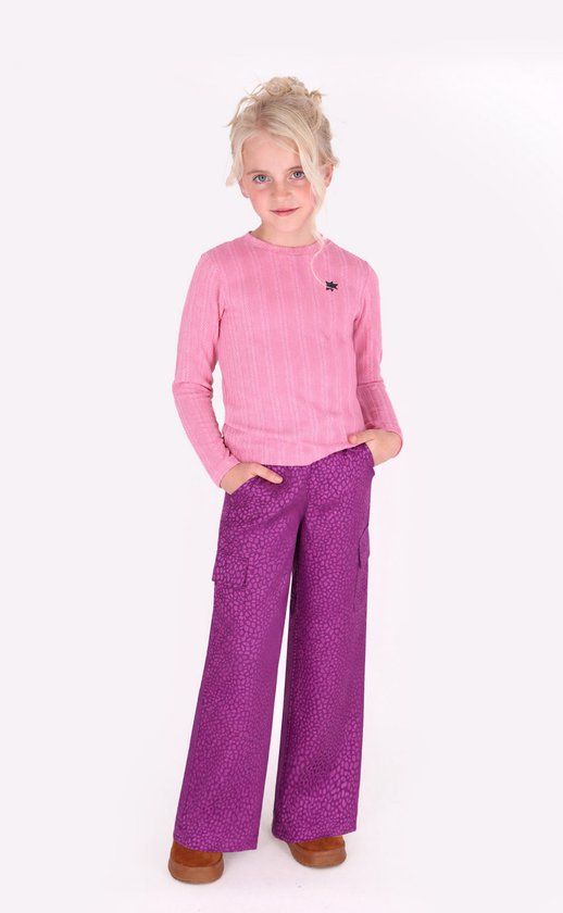 Meisje met blonde knotjes, draagt een roze ribgebreide top en paarse broek met textuurprint en cargozakken.