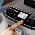 Vinger drukt op de "+" knop op het display van een De'Longhi Magnifica koffiemachine tijdens het ontkalken.