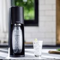 Zwarte SodaStream Terra met bruisende fles en glas met limoen.