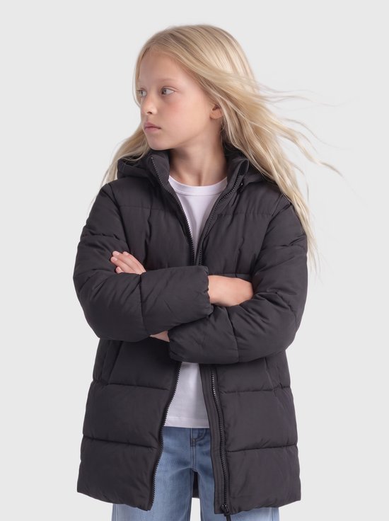 Model met blond haar, armen gekruist, draagt een lange, donkergrijze pufferjas met capuchon en rits.