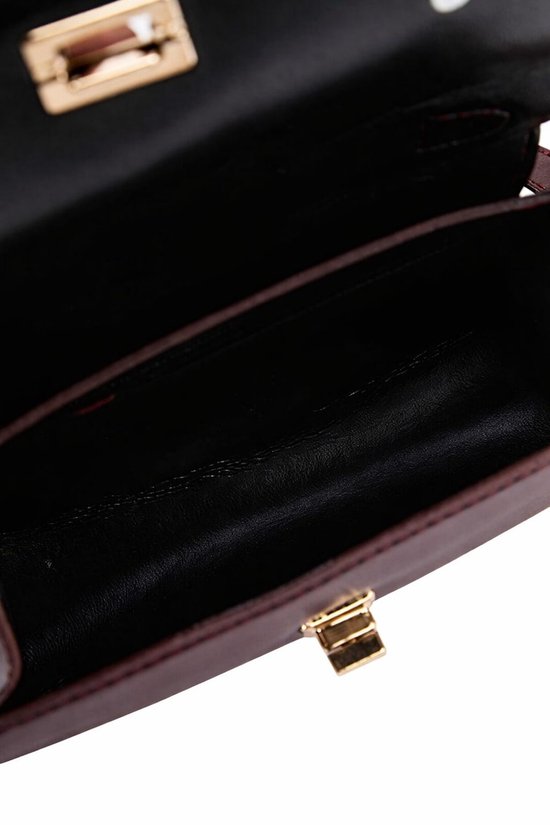 Open bordeauxrode handtas met goudkleurige gesp en een donker interieur.