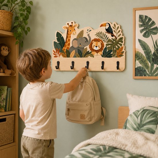 Jongetje hangt rugzak aan houten kapstok met jungle dieren in een kinderkamer.