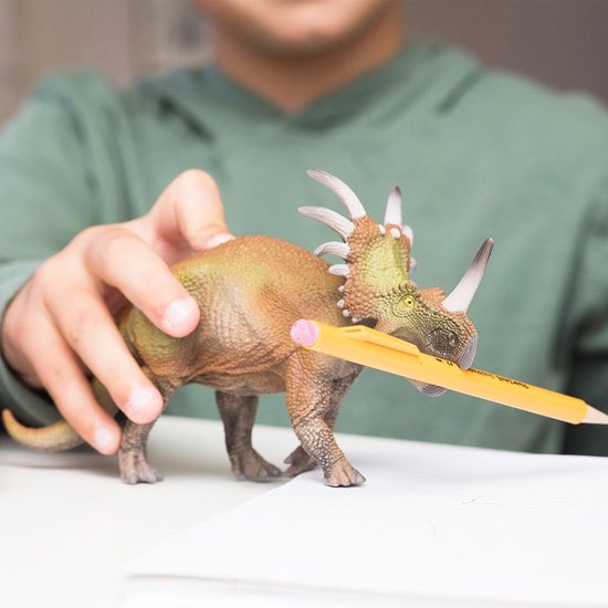 Gedetailleerd Triceratops speelfiguur met hoorns en kraag, met een potlood in zijn mond.