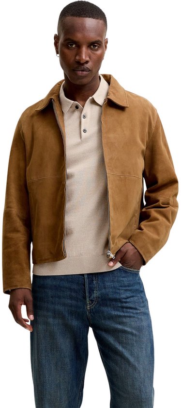 Man met beige gebreid poloshirt en bruine suède jas, met donkerblauwe jeans.