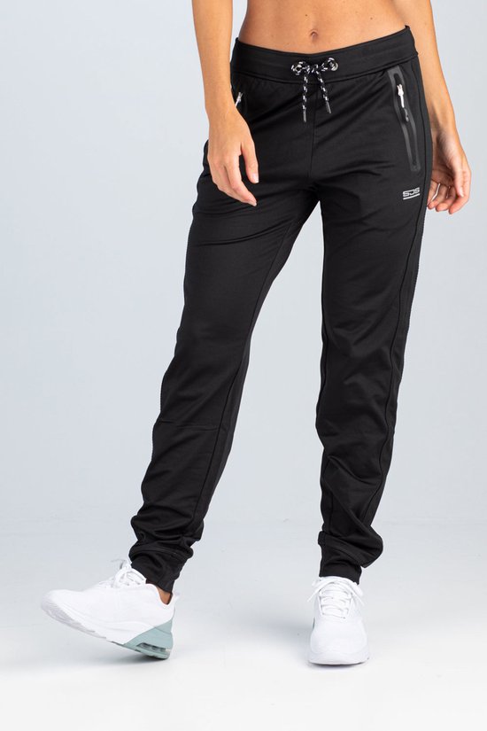 Zwarte trainingsbroek voor dames van Sjeng Sport met witte veters, ritszakken en een logo.