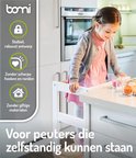 Meisje in grijze vest en roze jurk staat in een witte keukentoren. Met "Stabiel, robuust ontwerp".