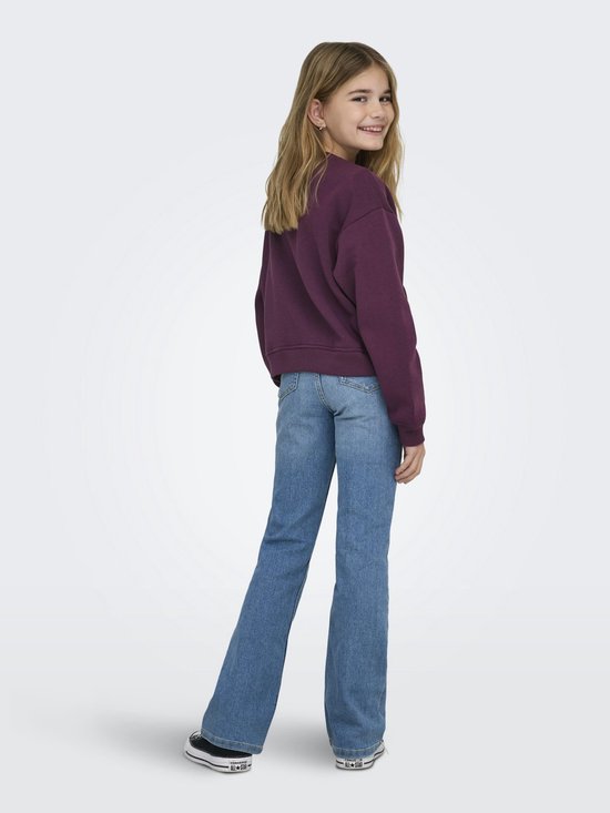 Meisje draagt een bordeauxrode sweater met 'LOS ANGELES CALIFORNIA' tekst en wijde jeans, van achteren gezien.