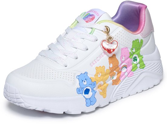 Witte sneaker met Care Bears-print: Groene beer met klavertje vier, roze beer met regenboog, oranje beer met bloem, gele beer met zon, blauwe beer met hart. Met hartvormige bedel.