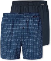 Twee boxershorts naast elkaar. Eén donkerblauwe met een all-over print van lichte streepjes en één effen donkerblauwe.