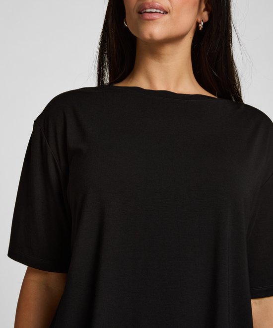 Close-up van het zwarte pyjamashirt met ronde hals op een model.