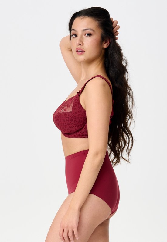 Zijaanzicht van een model in een bordeauxrode bh met luipaardprint en bijpassende hoge slip, hand naar het haar.