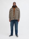 Man draagt een bruine hoodie onder een geruit overhemd.