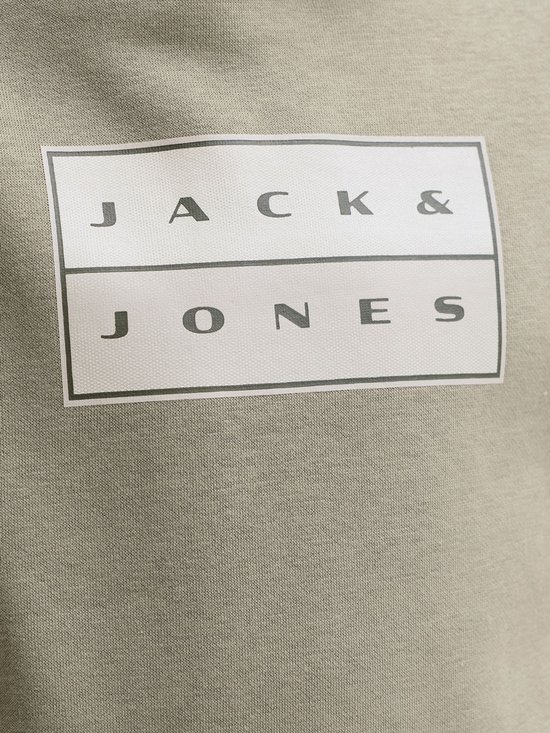 Detail van het 'JACK & JONES' logo op een olijfgroene stof.