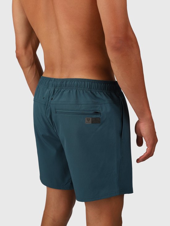 Vue arrière d'un homme en short de bain bleu-vert avec une poche zippée et une étiquette logo.