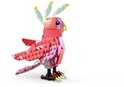 Een roze LEGO kaketoe met roze en lichtroze veren, witte accenten op de kop en lichtgroene kuiven. De poten zijn bruin met gele klauwen.