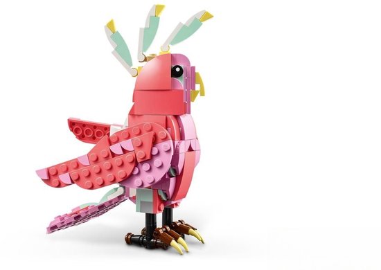 Een roze LEGO kaketoe met roze en lichtroze veren, witte accenten op de kop en lichtgroene kuiven. De poten zijn bruin met gele klauwen.